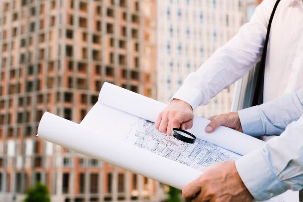 A mid-construction building site with the permit board posted at the fence — the moment a project depends on a permit staying active through its inspections