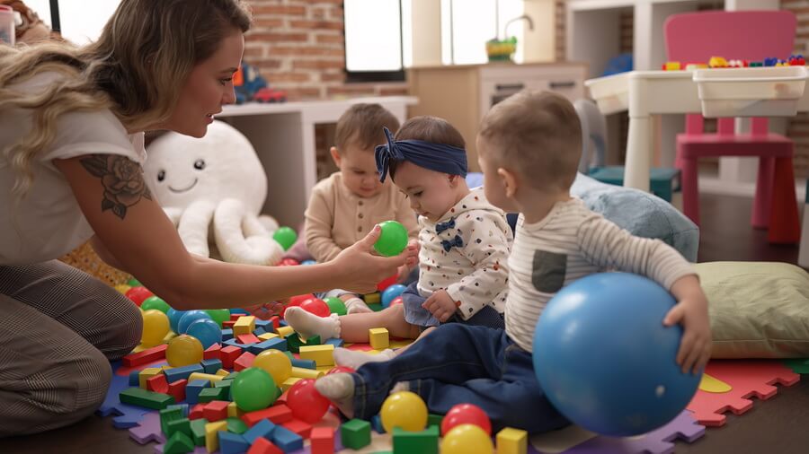 A bright daycare classroom with the childcare license posted by the door — one facility license sustained by staff checks, training hours, inspections, and ratios