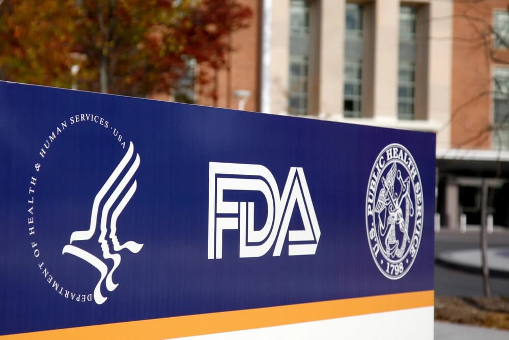 A food-production facility beside a laptop tracking the fixed October–December biennial FDA registration renewal window