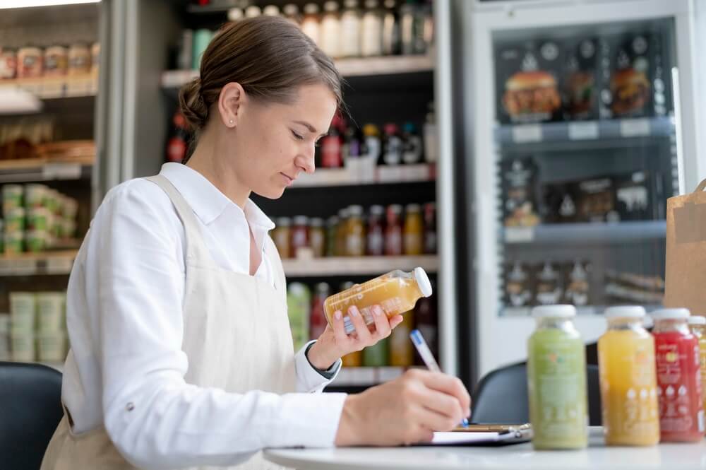 Kitchen staff preparing food while a manager tracks every food handler card, the certified food protection manager credential, and each new hire's certification deadline