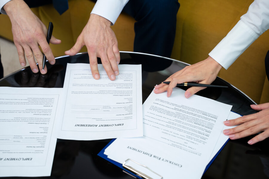 Compliance, finance and legal staff reviewing filing documents together around a table - the multi-person review a Form ADV annual updating amendment requires within 90 days of fiscal year-end