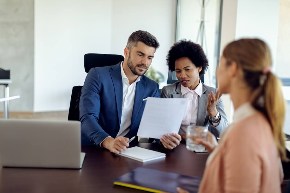 An insurance agent meeting a client while the agency tracks every producer's state licenses, carrier appointments, and continuing education deadlines