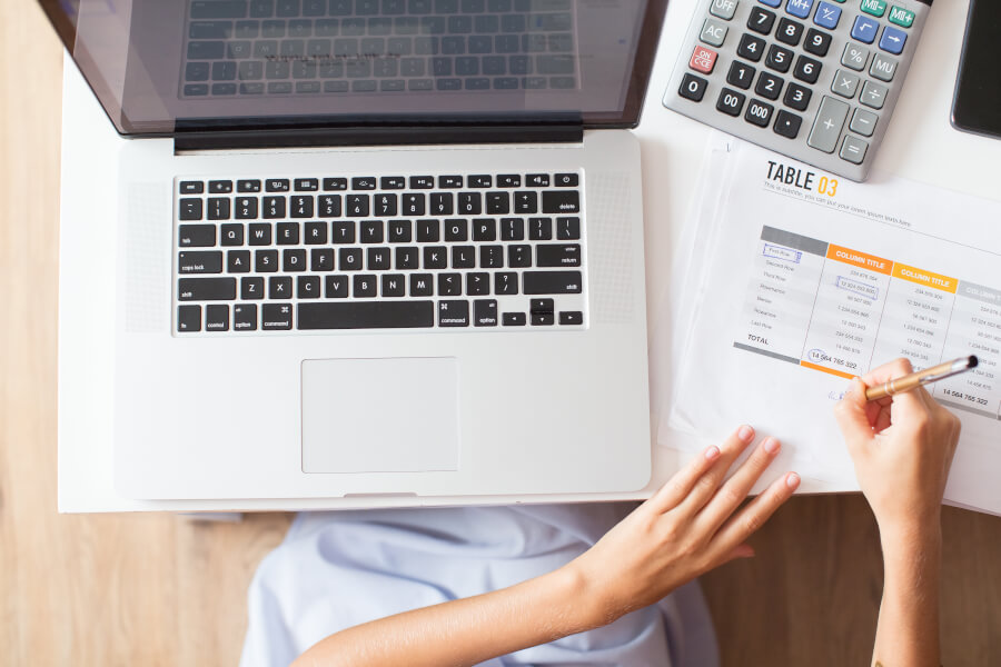 A lawyer at a desk comparing a bank statement against client ledger records while performing a trust account reconciliation
