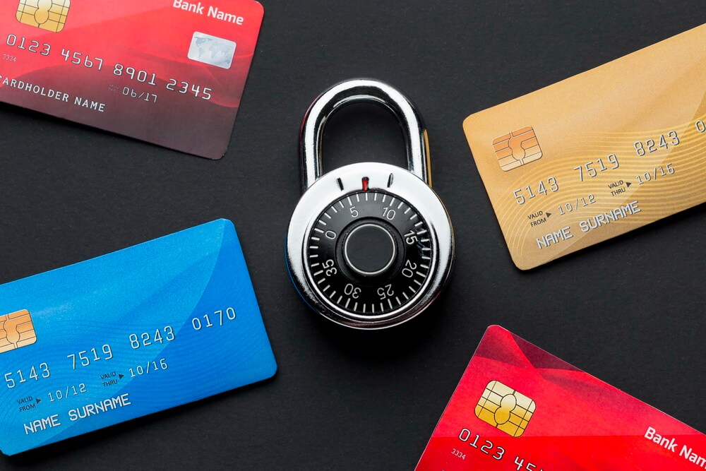 A card payment terminal beside a laptop tracking the annual PCI DSS attestation renewal and the quarterly ASV vulnerability-scan dates