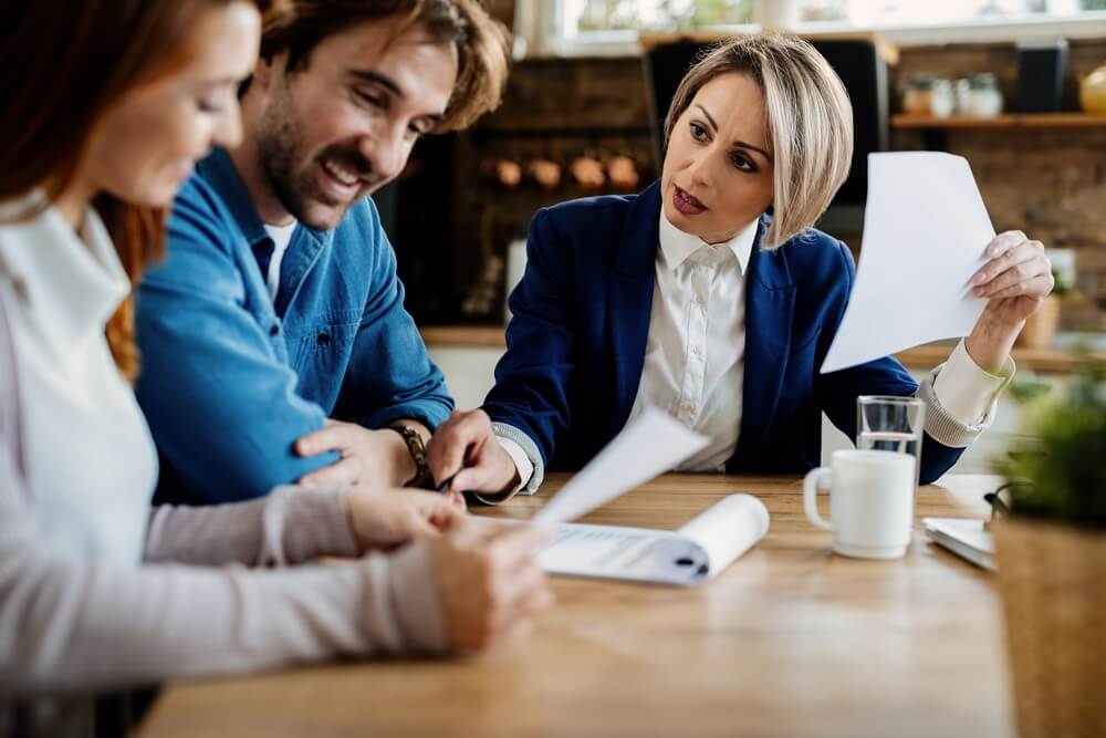 A professional advisor reviewing documents with clients at a desk — the advisory work that professional liability (E&O) insurance protects