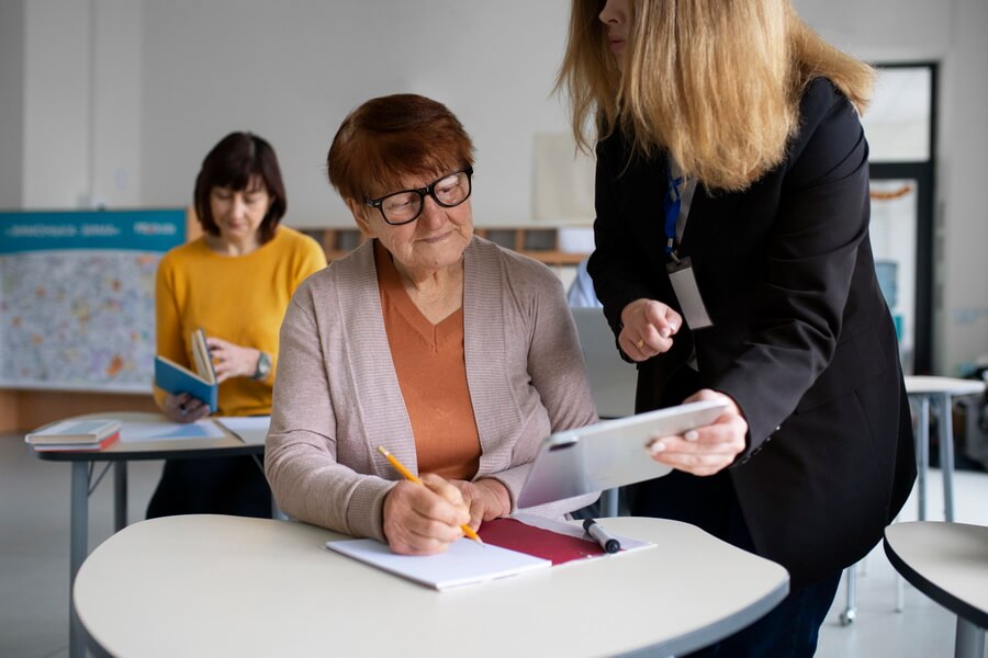 A teacher at a classroom whiteboard — behind every teaching career sits a staged certification with an advancement window, a renewal cycle, and continuing-education requirements