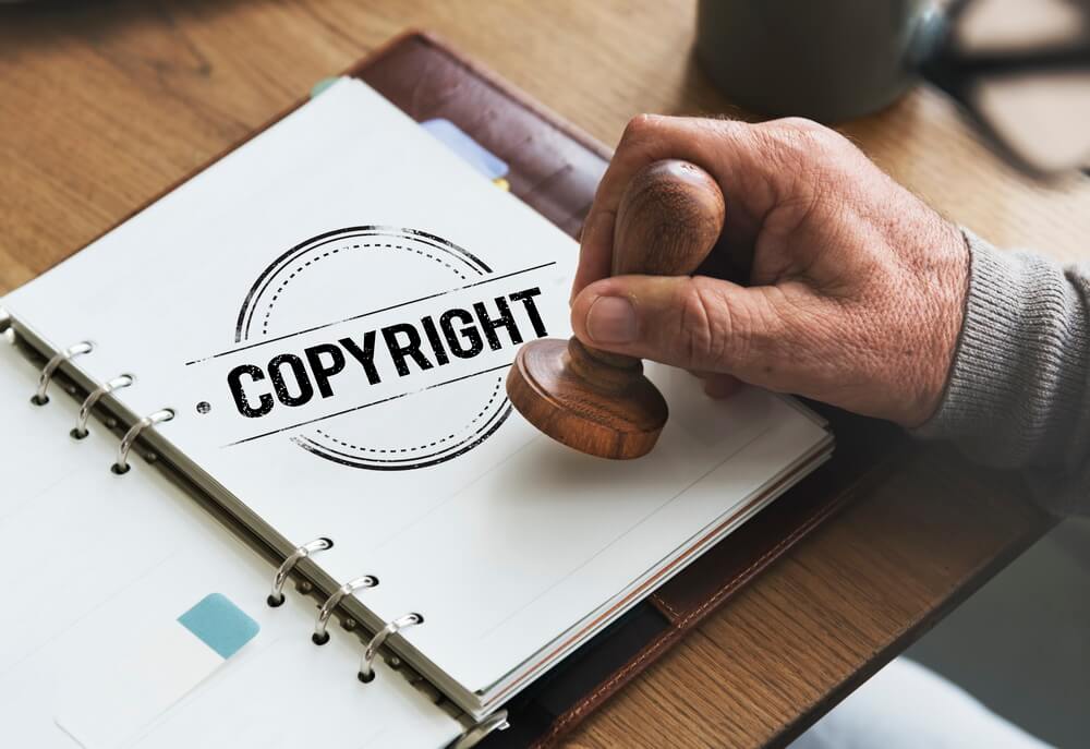 A registered brand name and logo beside a laptop tracking each trademark's Section 8 and renewal maintenance deadlines across a ten-year term