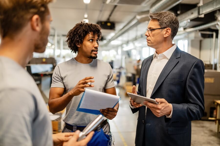 A project manager reviewing a subcontractor's compliance paperwork on site — the third-party documents whose expiry dates decide who carries the risk