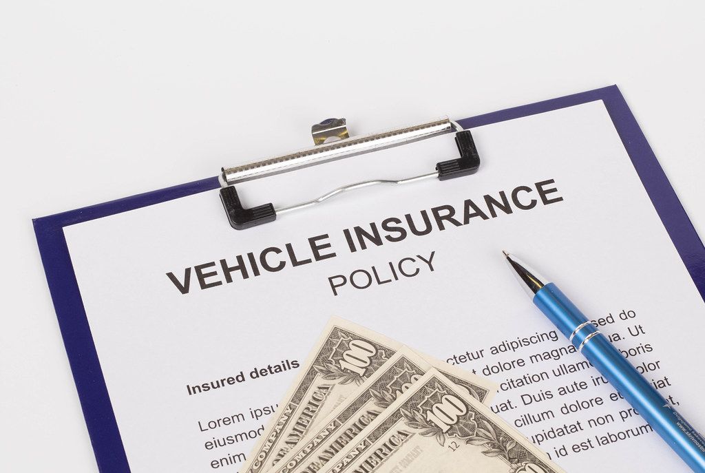 Vehicle insurance policy document with toy car