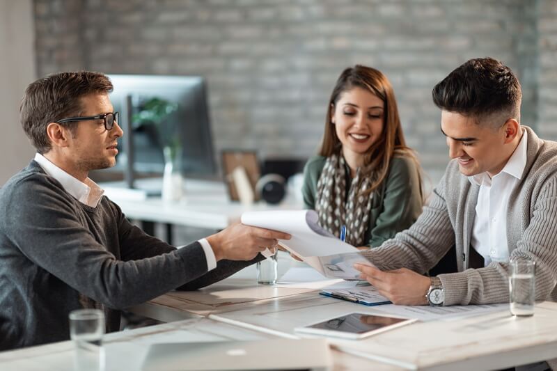 Real estate broker handing over keys after successful property transaction